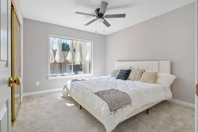 a white bedroom with a bed and a ceiling fan at Stylish & Bright ~ Huge Backyard ~ King Beds ~ Pkg in Palmdale