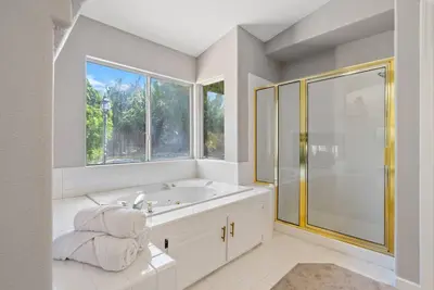 a bathroom with a tub and a glass shower at Stylish & Bright ~ Huge Backyard ~ King Beds ~ Pkg in Palmdale