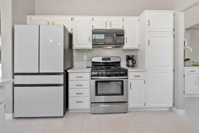 a kitchen with white appliances and white cabinets at Stylish & Bright ~ Huge Backyard ~ King Beds ~ Pkg in Palmdale