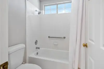 a white bathroom with a toilet and a shower at Stylish & Bright ~ Huge Backyard ~ King Beds ~ Pkg in Palmdale