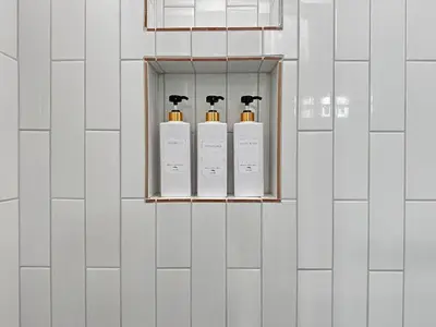 a row of four perfume bottles on a white tiled wall at Discount For 30 Days Plus Stay In Culver City in Los Angeles