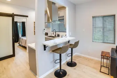 a kitchen and living room with a counter and stools at Pet-Friendly Riverside Vacation Rental with Patio! in Riverside