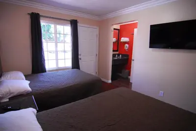 a hotel room with two beds and a window at Studio City Inn - Near Universal Studios Hollywood in Los Angeles