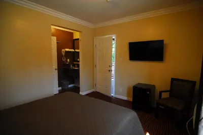 a bedroom with a bed and a television on the wall at Studio City Inn - Near Universal Studios Hollywood in Los Angeles