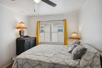 a bedroom with a bed and two lamps and a window at Walk to Retro Row Long Beach Condo in Long Beach