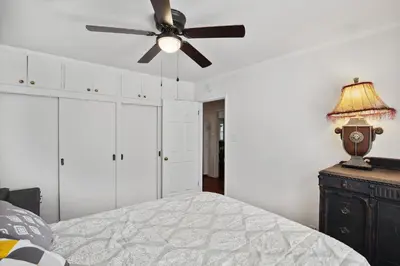 a bedroom with a ceiling fan and a bed at Walk to Retro Row Long Beach Condo in Long Beach