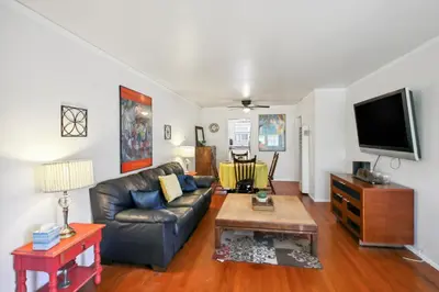 a living room with a leather couch and a tv at Walk to Retro Row Long Beach Condo in Long Beach