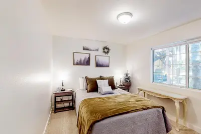 a white bedroom with a bed and a window at Lake Gregory Escape in Crestline