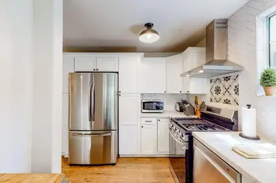 a kitchen with white cabinets and a stainless steel refrigerator at Lake Gregory Escape in Crestline