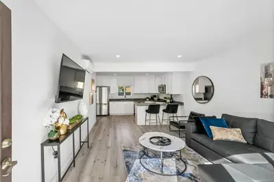 a living room with a couch and a table at Muirfield Chic City Bungalow with Parking 1,2,3 in Los Angeles