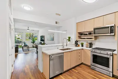 a kitchen with wooden cabinets and stainless steel appliances at Beverly Grove Chic City Oasis 2 BR Apt with Den 138 in Los Angeles