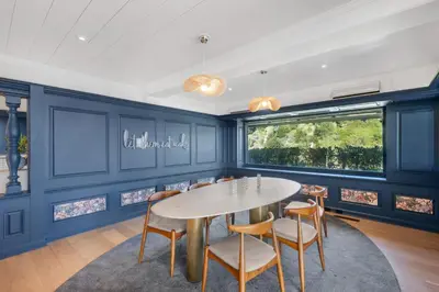 a dining room with blue walls and a table and chairs at Beverly Tree House in Los Angeles