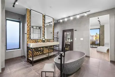a bathroom with a large tub and a sink at NEW Luxury Concrete Home Just Minutes from the Beach in Long Beach