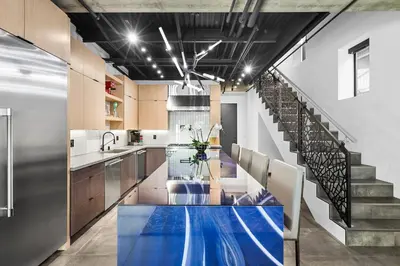 a kitchen with a blue table and a staircase at NEW Luxury Concrete Home Just Minutes from the Beach in Long Beach