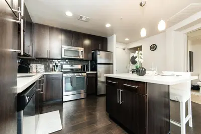 a kitchen with wooden cabinets and a white counter top at Stylish Vibes 1BD in WEHO in Los Angeles