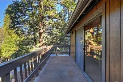 a balcony of a house with trees in the background at Arrowhead Lake Cabin pool table stunning views in Lake Arrowhead