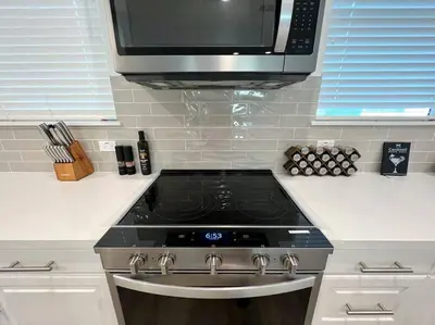a kitchen with a stove and a microwave at Modern Lux Home Near Disneyland And In The Heart Of OC! in Santa Ana