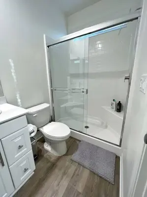 a white bathroom with a shower and a toilet at Modern Lux Home Near Disneyland And In The Heart Of OC! in Santa Ana
