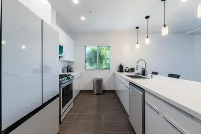 a kitchen with white countertops and a sink at Hotel Mai Downtown Long Beach in Long Beach