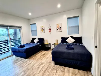 a bedroom with two beds and a couch at 4BR/4BR modern house at Mid-city in Los Angeles