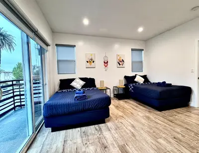 a bedroom with two beds and a balcony at 4BR/4BR modern house at Mid-city in Los Angeles