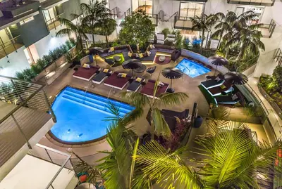 an overhead view of a hotel pool with chairs and umbrellas at Fairfax District Chic City Oasis 2 BR Apt with Den 136 in Los Angeles
