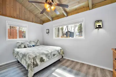 a bedroom with a bed and a ceiling fan at Storyville Hot Tub- Arcade- Walk To Marina Cabin in Big Bear Lake