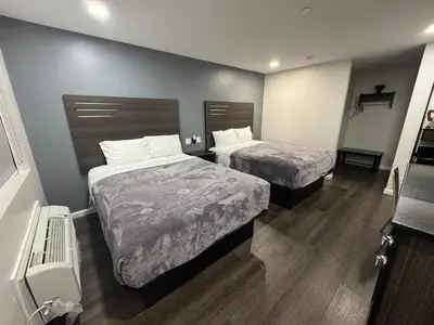 two beds in a small room with wood floors at Deep Creek in Arrowbear Lake