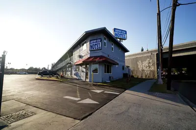 an empty parking lot next to a blue building at Airport Stay Motel in Ontario
