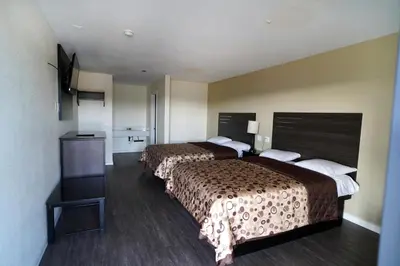 a hotel room with two beds and a television at Airport Stay Motel in Ontario