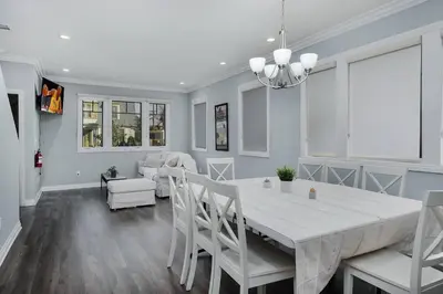 a dining room and living room with a white table and chairs at Stylish 4 BR house near Korea Town (Central LA) in Los Angeles
