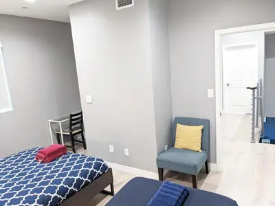 a bedroom with a bed and a chair at Lucky Charm 4 Bedroom Mid-City Apartment in Los Angeles
