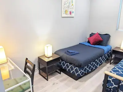 a small bedroom with a bed and two lamps at Lucky Charm 4 Bedroom Mid-City Apartment in Los Angeles