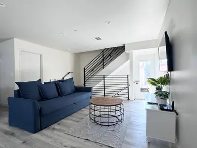 a living room with a blue couch and a table at Cozy Chamber 3 BR Hollywood Townhouse in Los Angeles