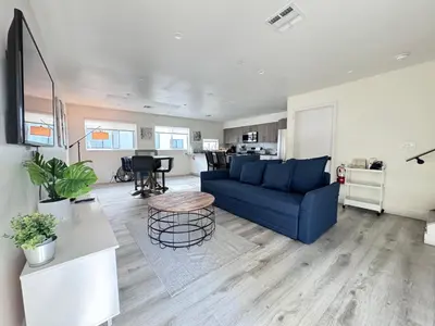 a living room with a blue couch and a table at Cozy Chamber 3 BR Hollywood Townhouse in Los Angeles