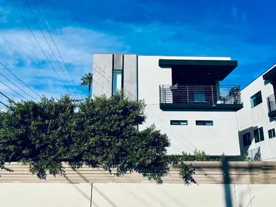 a white building with a tree in front of it at Cozy Chamber 3 BR Hollywood Townhouse in Los Angeles
