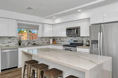 a white kitchen with a large marble counter top at Wonderful 3 Bedroom Home Perfect for Getaway in Los Angeles