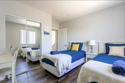a bedroom with two beds and a mirror at 5 BR Home Near USC - Perfect Location in Los Angeles
