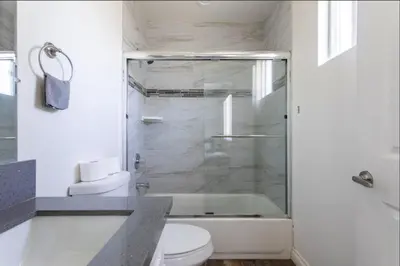 a bathroom with a shower and a toilet and a sink at 5 BR Home Near USC - Perfect Location in Los Angeles