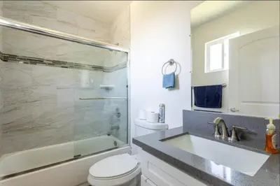 a bathroom with a shower and a toilet and a sink at Cheerful 5BR house with parking near USC in Los Angeles