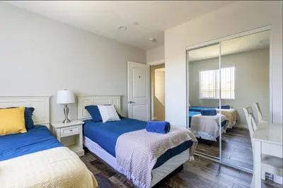 a bedroom with two beds and a mirror at Cheerful 5BR house with parking near USC in Los Angeles