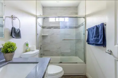 a bathroom with a glass shower and a toilet at Cheerful 5BR house with parking near USC in Los Angeles