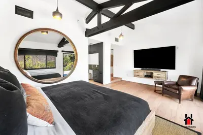a large bedroom with a large mirror and a bed at Resort Feel I Breathtaking Mountain Scenery I Pool in Malibu