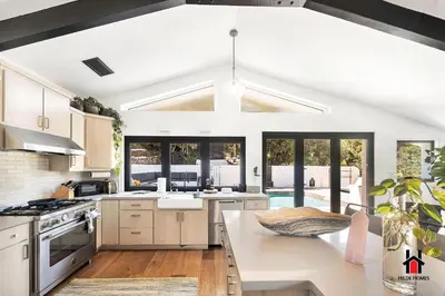 a kitchen with white cabinets and a large window at Resort Feel I Breathtaking Mountain Scenery I Pool in Malibu