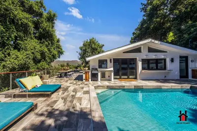 a swimming pool in front of a house at Resort Feel I Breathtaking Mountain Scenery I Pool in Malibu