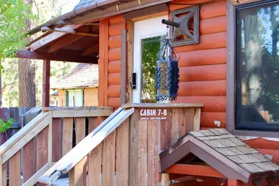 a front porch of a cabin with a sign on it at Boulder Bay Cottages in Big Bear Lake