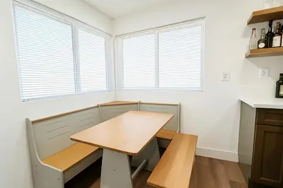 a kitchen with a table and a bench and windows at Bright Corner Home Retreat Near SoFi in Los Angeles