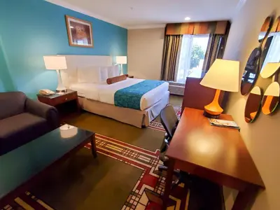 a hotel room with a bed and a couch at Howard Johnson by Wyndham Pasadena in Pasadena