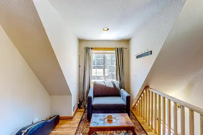 a stair room with a chair and a window at Heliotrope Hideaway in Lake Arrowhead