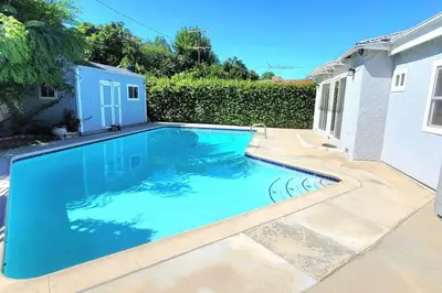 a swimming pool with blue water in a yard at Newly Furnished Pool House in Los Angeles